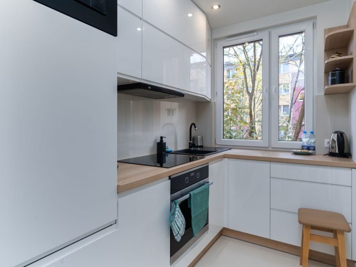 Cocina blanca equipada con horno y ventana en piso de Elda
