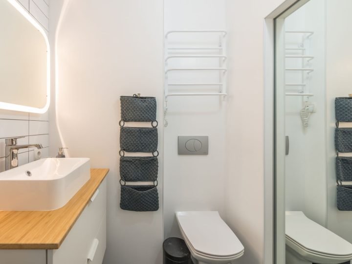 Baño completo con lavabo y espejo iluminado en piso de Elda