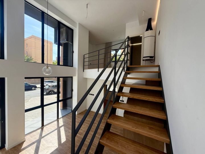 Escalera de madera con barandilla metálica negra
