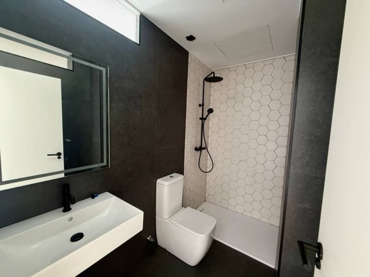 Baño con lavabo blanco y espejo con luz