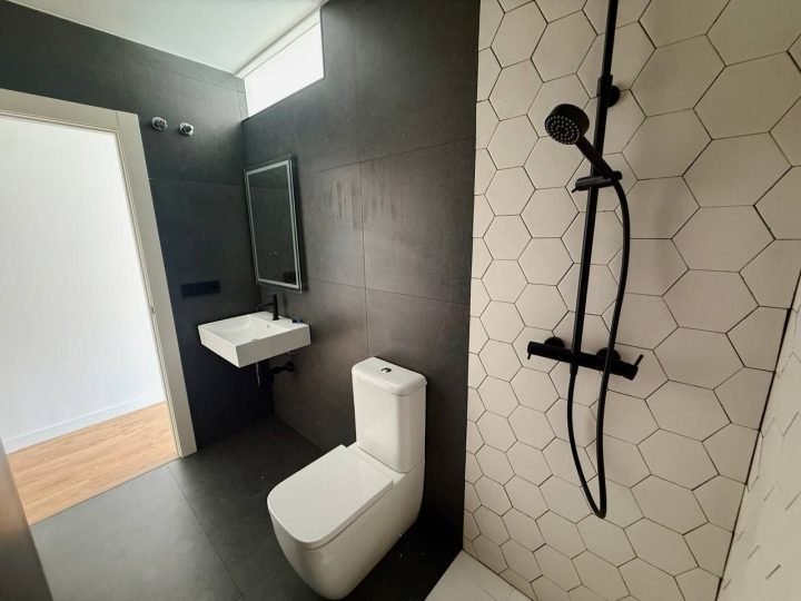 Baño con ducha de lluvia y alicatado hexagonal