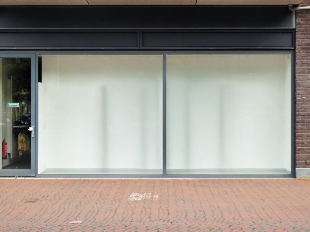 Local comercial vacío con escaparate de cristal a pie de calle